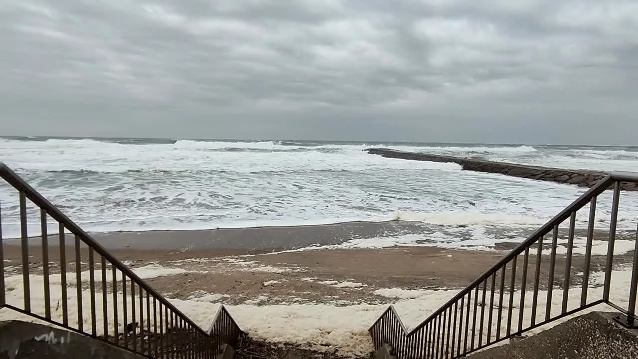 Storm weather Breaking waves and seafoam at the beach shore Tracking in