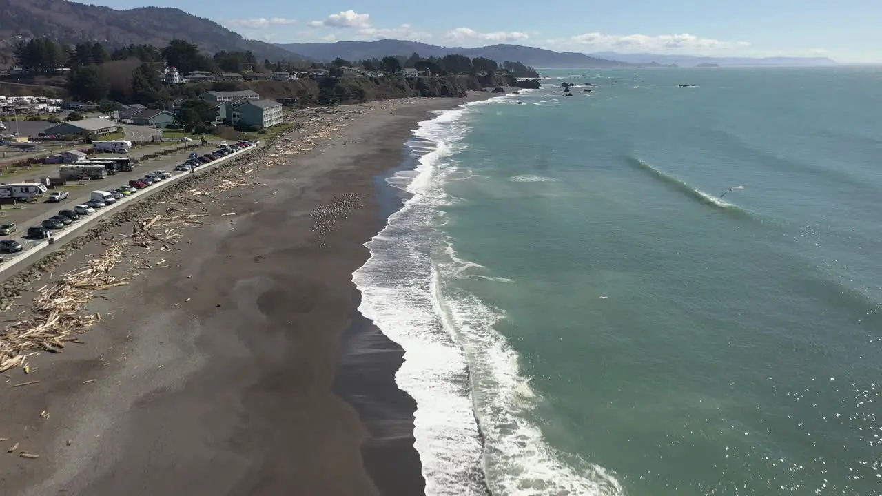 Aerial View Of White Foamy Waves Splashing On Sandy Shore Of Beach In Brookings Oregon drone shot