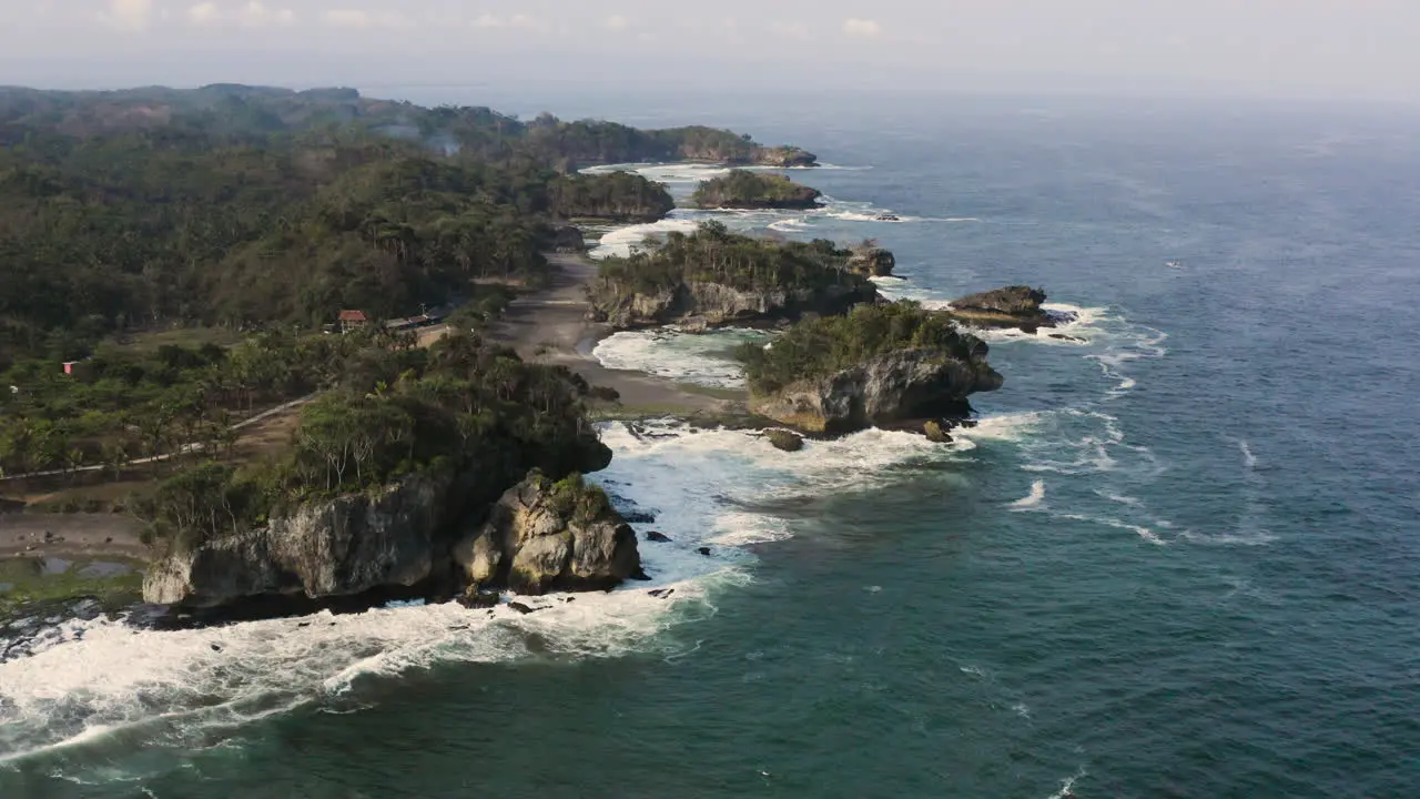 Natural coastline with tropical forest and crashing waves along the coastline