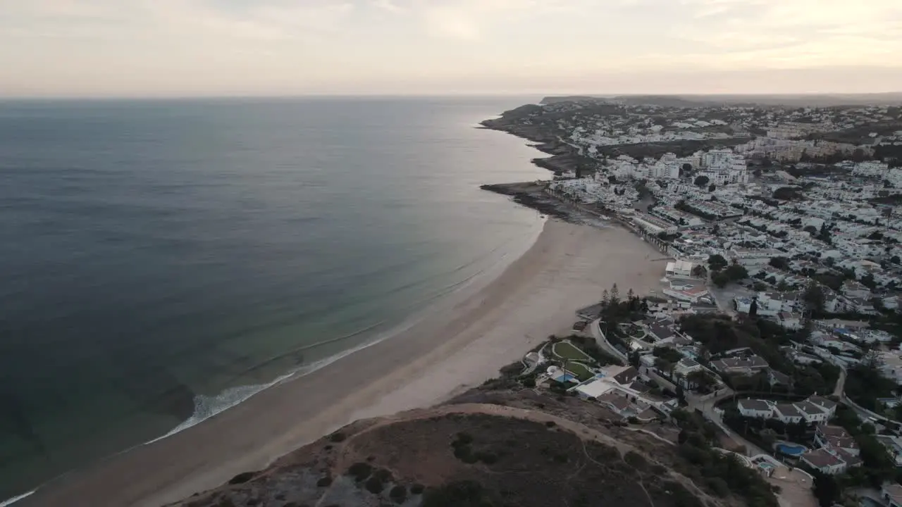 Small ocean waves gently unfolding on sand beach Praia da Luz Algarve