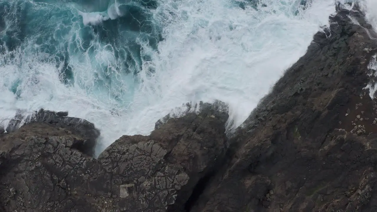 Aerial Topdown View Of Ocean Waves Splashing Against The Rocky Coast Of Vagar Cliff In Faroe Island Denmark