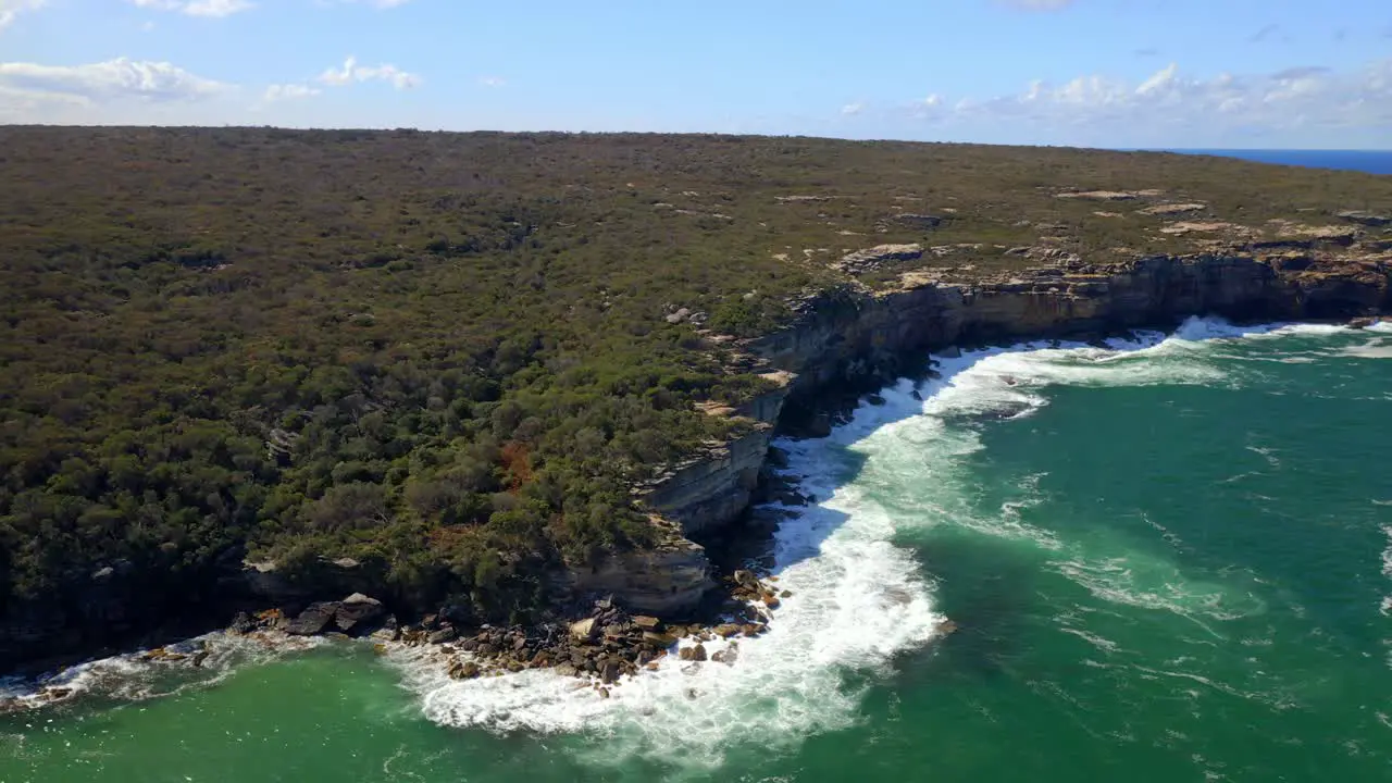 Waves Crash Through Sandstone Coastal Cliffs With Lush Vegetation At Royal National Park In Sydney New South Wales Australia