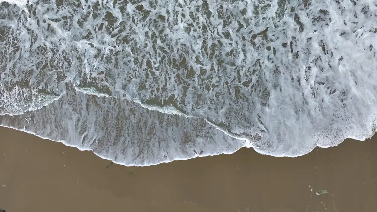 Aerial Of Foamy Ocean Waves Hitting The Beach Slow Motion