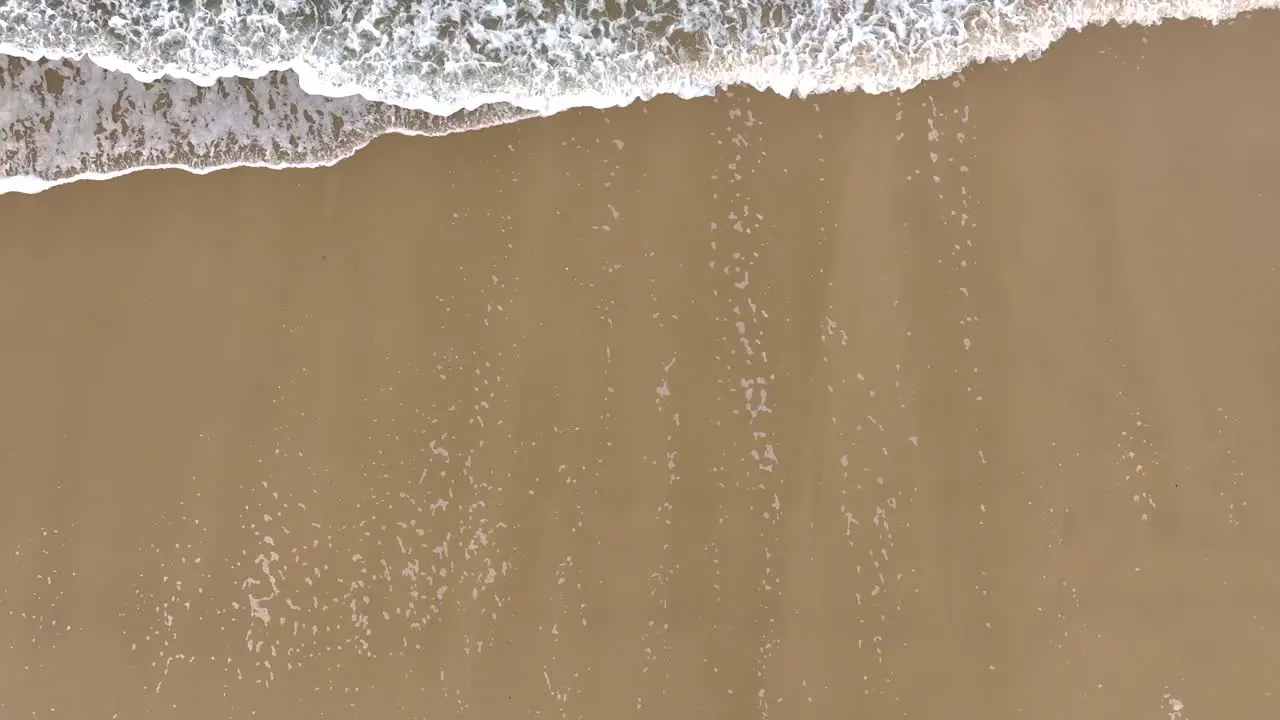 Sandy Shore With Foamy Ocean Waves Aerial Top Down