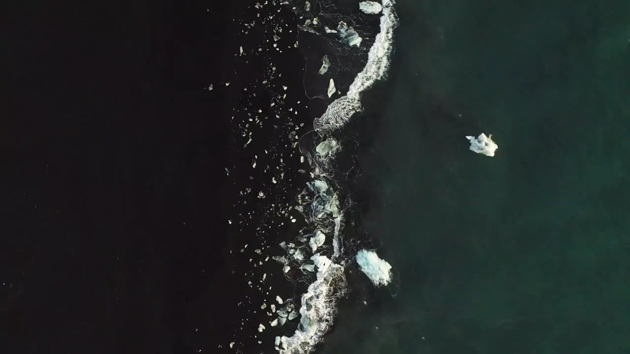 Ocean Waves Splashing On Shore Of Black Diamond Beach In Iceland aerial top down