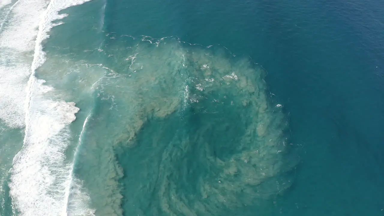 Top view of blue moving ocean waves and sand next to the big beautiful island Fraser Island Australia