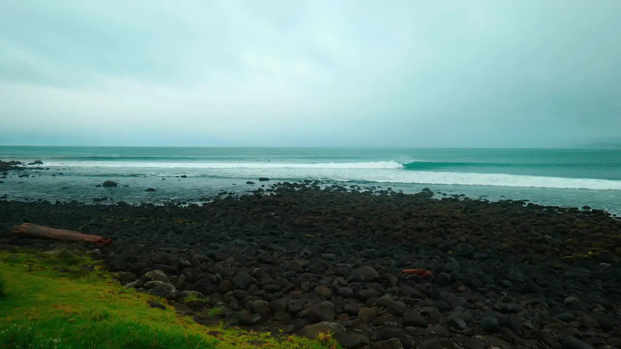 A breathtaking wide-shot captures the dynamic beauty of a surf break where the ocean's waves crash and create a mesmerizing spectacle along the coastline