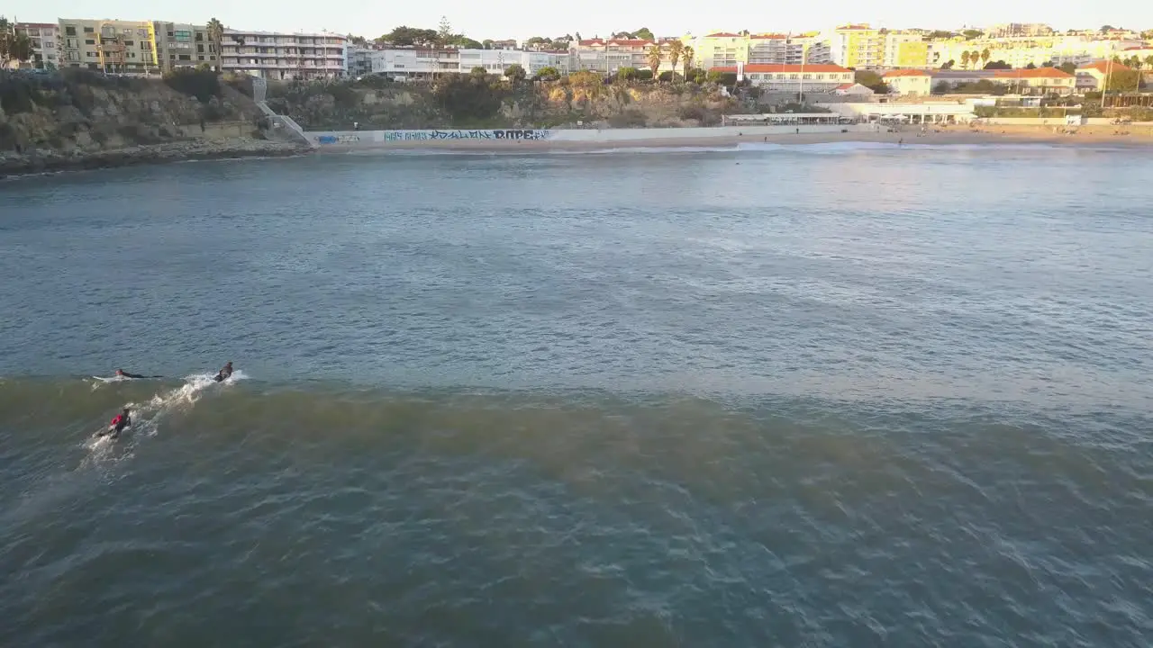 Multiple surfers attempting to catch waves without success at a pointbreak in Portugal