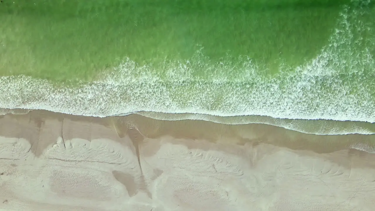 Aquamarine ocean waves gently crashing onto sandy Paternoster beach top aerial