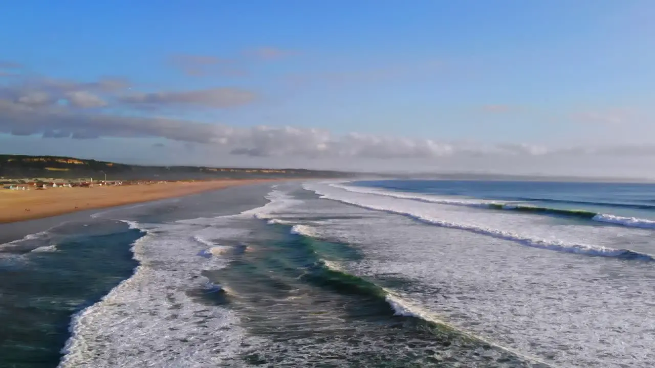 Drone descending filming the waves on the beach in Costa Da Caparica