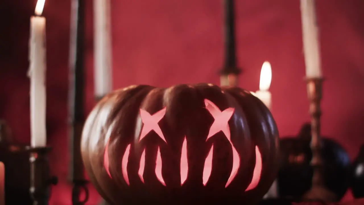 Video of halloween carved pumpkin candles and smoke with copy space on red background