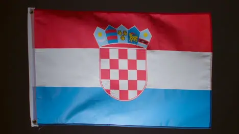 Studio Shot Of Flag Of Croatia Falling Down Against Black Background