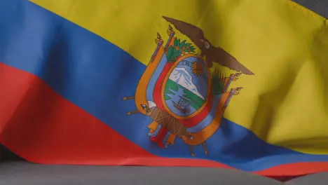 Close Up Of Flag Of Ecuador Draped Over Sofa At Home With Football Ready For Match On TV