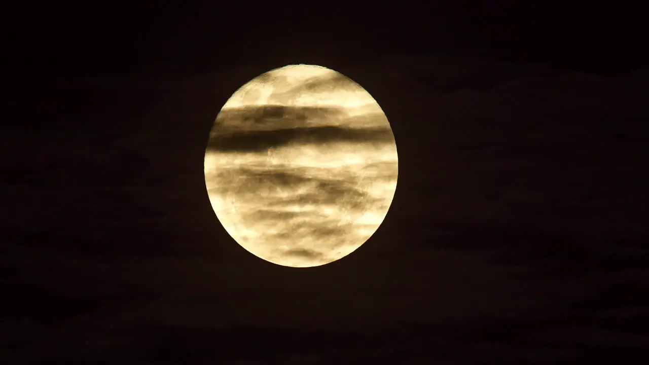 Mesmerising moonrise in dark night sky clouds moving past