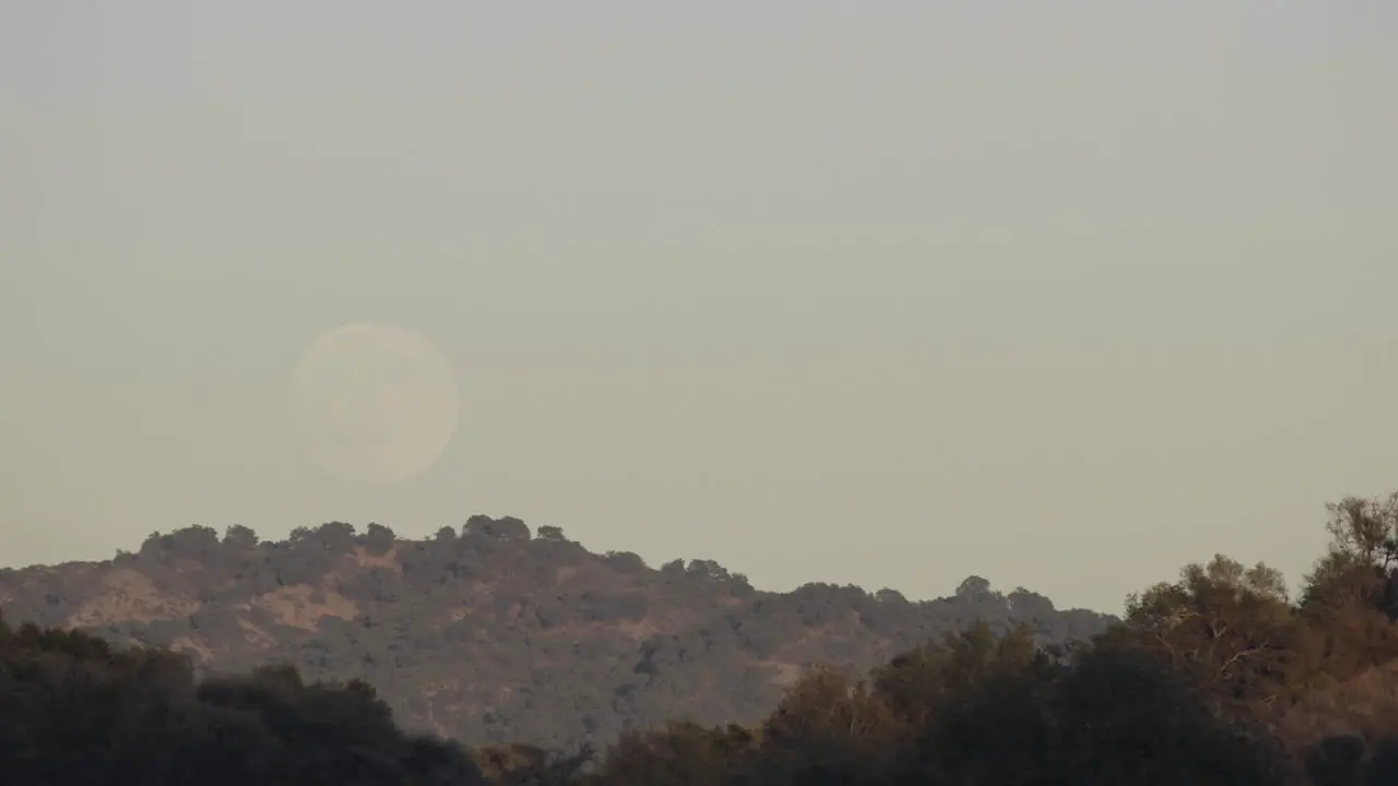 Time lapse of full moon rising over a landscape in Oak View California