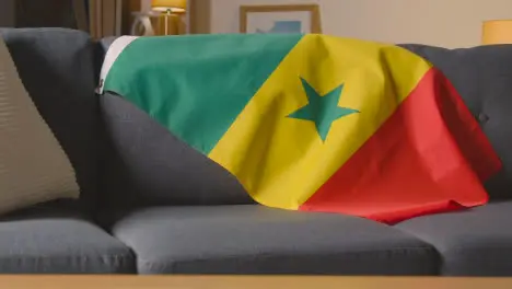 Flag Of Senegal Draped Over Sofa At Home Ready For Match On TV