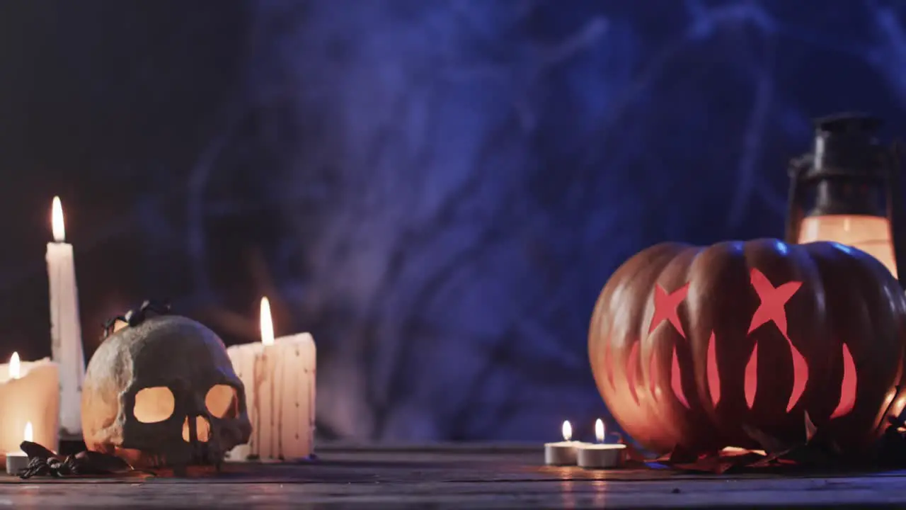 Video of halloween carved pumpkin skull candles and smoke with copy space on purple background