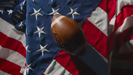 Overhead Studio Shot Of American Football On Stars And Stripes Flag 