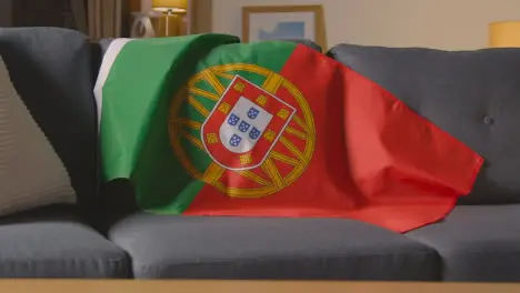 Flag Of Portugal Draped Over Sofa At Home Ready For Match On TV