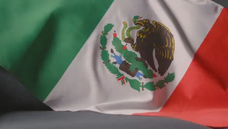 Close Up Of Flag Of Mexico Draped Over Sofa At Home Ready For Match On TV