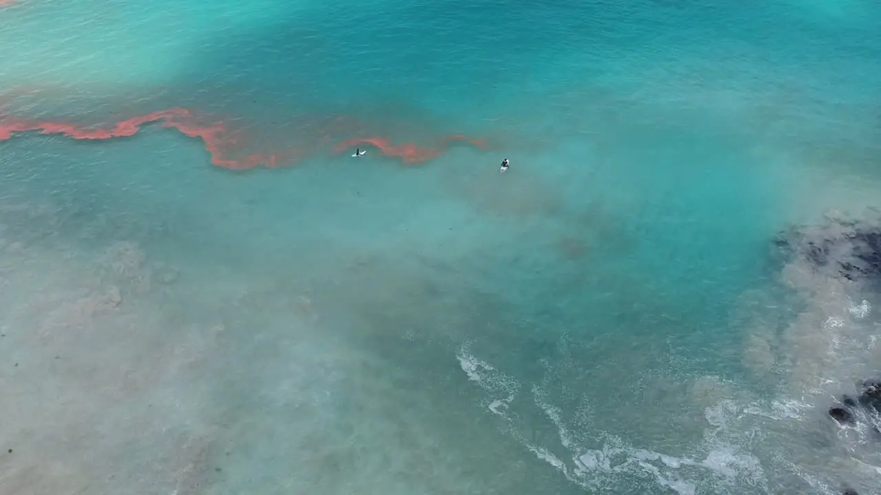 Surfers Surfing At Turquoise Blue Water Of Shirahama Beach With Rocky Coastline In Japan