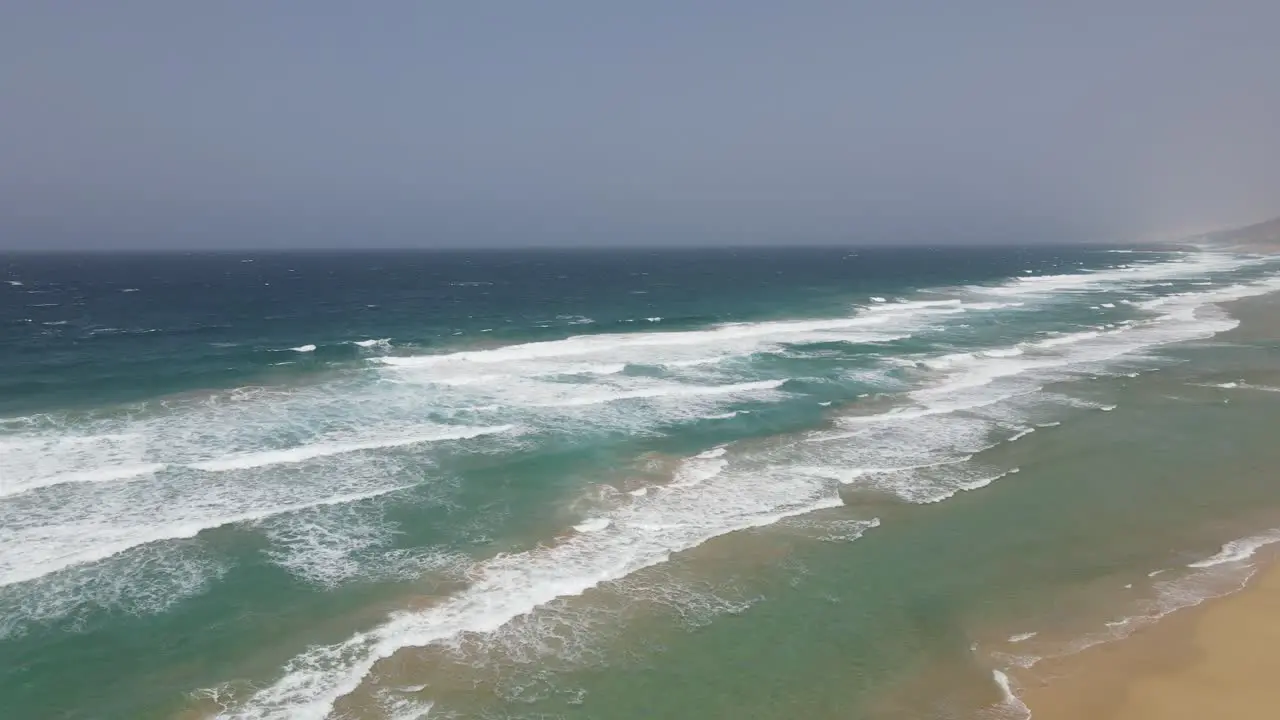 aerial drone shot of big waves crashing on the beach of cofete in Fuerteventura canary island