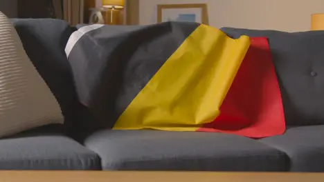 Flag Of Belgium Draped Over Sofa At Home Ready For Match On TV