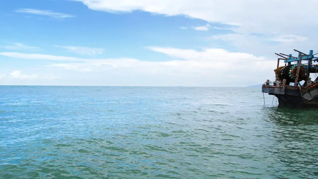 A zoom out shot of a tourist boat on a beautiful ocean with blue sky background