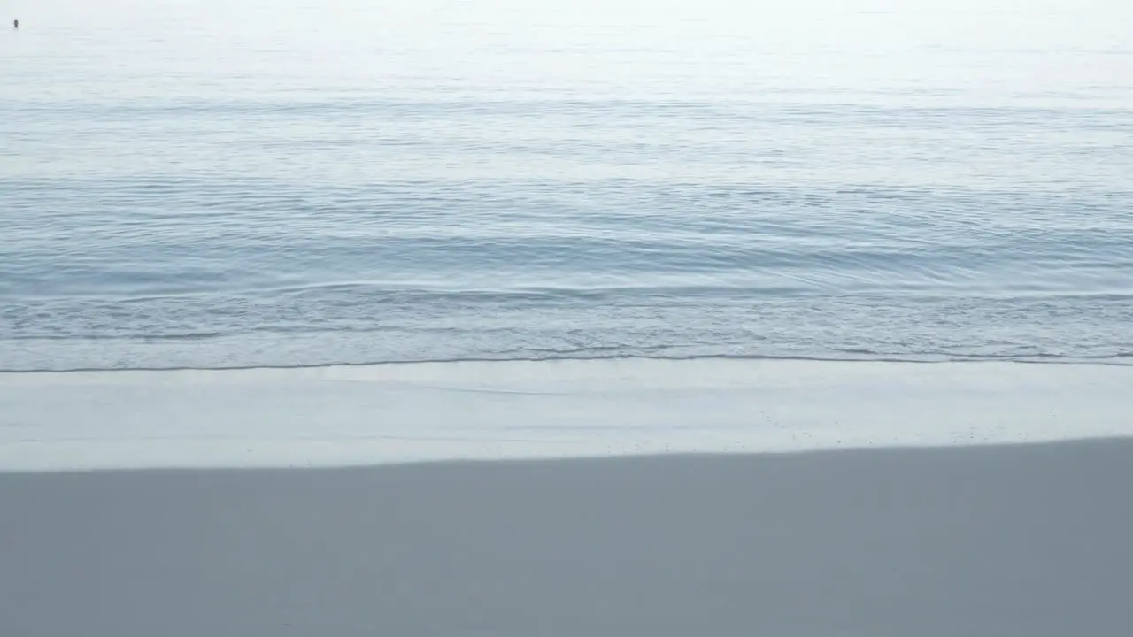 the beach with white sand and calm wave from peaceful sea in summer sunshine daytime