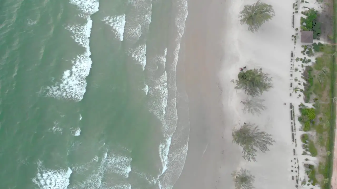 Cinematic aerial shot of big waves crashing onto island coastline in cambodia asia at sunset with deep glow from sun over the ocean water-1