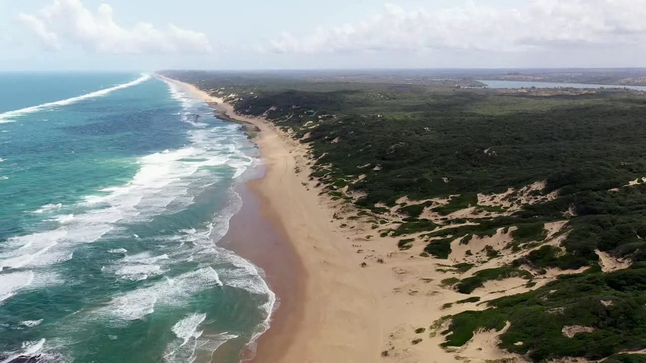 High Altitude Forward Flying Shot of Chidenguele Beach in Mozambique with Inhampavala Lake in Background