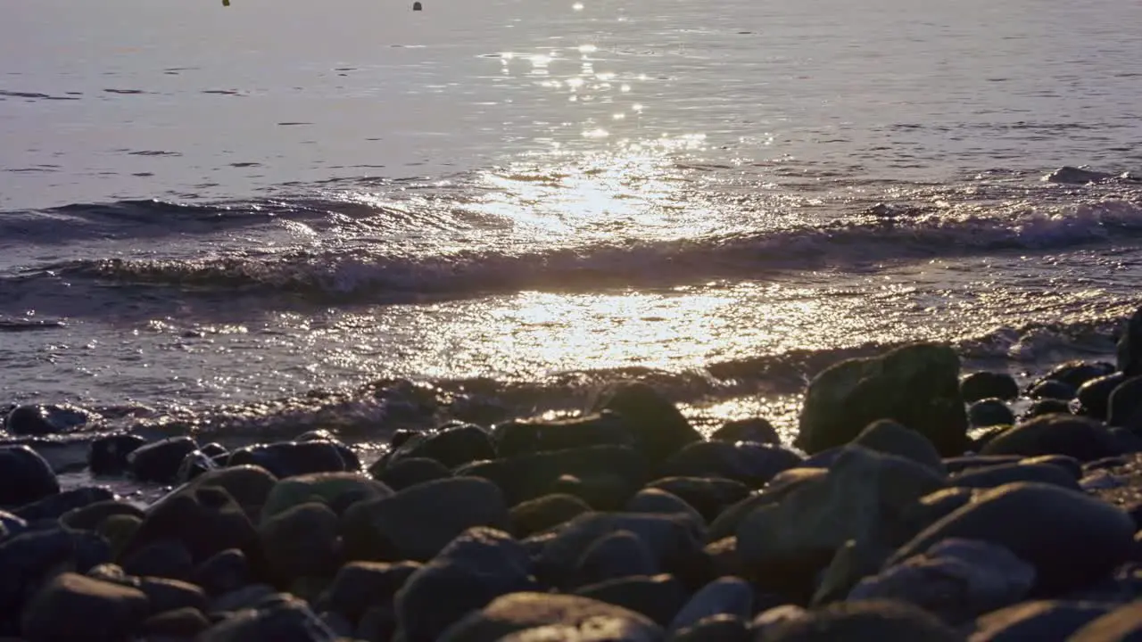 Sun reflection at the sea on a rocky beach