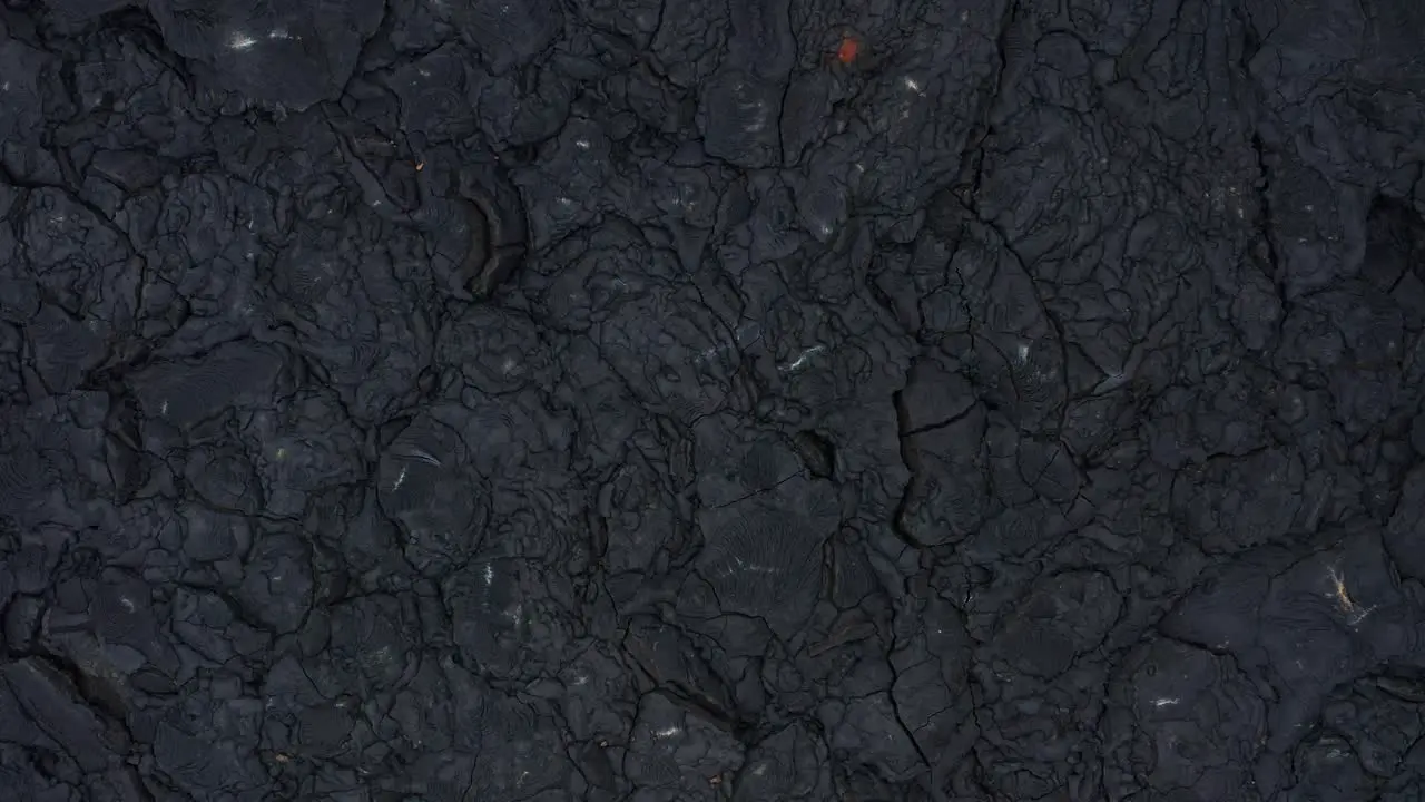 Dark black basalt rock solidified lava field cracked rugged surface