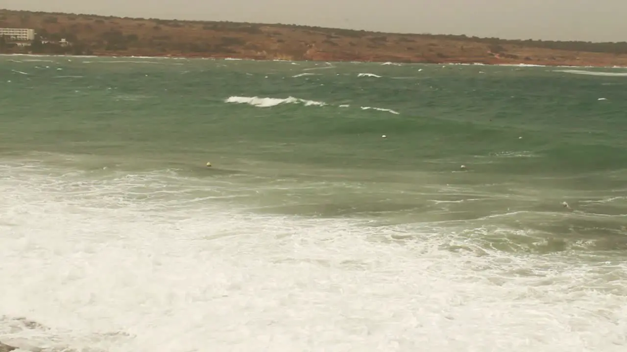 Waves splashing on sea dock on stormy cloudy windy day in Mellieha Malta