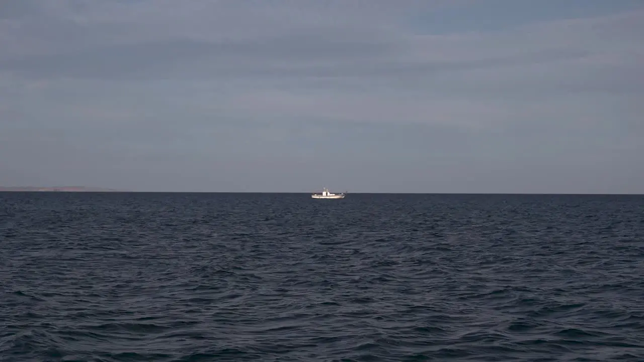 A fishing boat goes fishing on the open ocean on a sunny day In Larnaca Cyprus