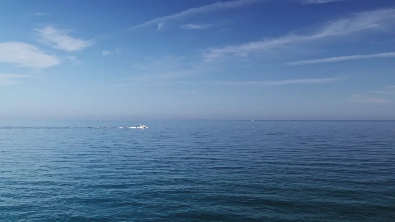 Calm blue ocean with boat passing by