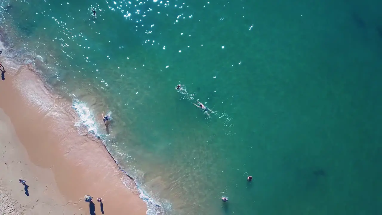 People splashing in turquoise water at beach in Australia during summer holiday