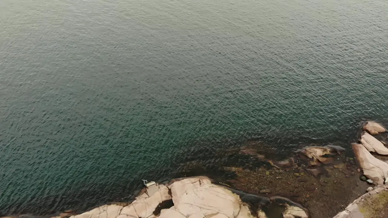 Overhead aerial over the rocky shoreline out to sea near Lysekil Sweden