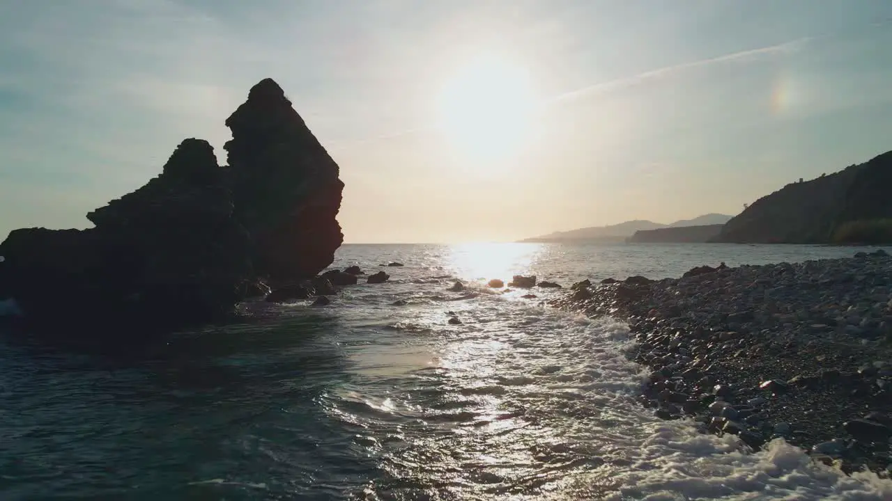 Drone moving forward between the rocks at the beach