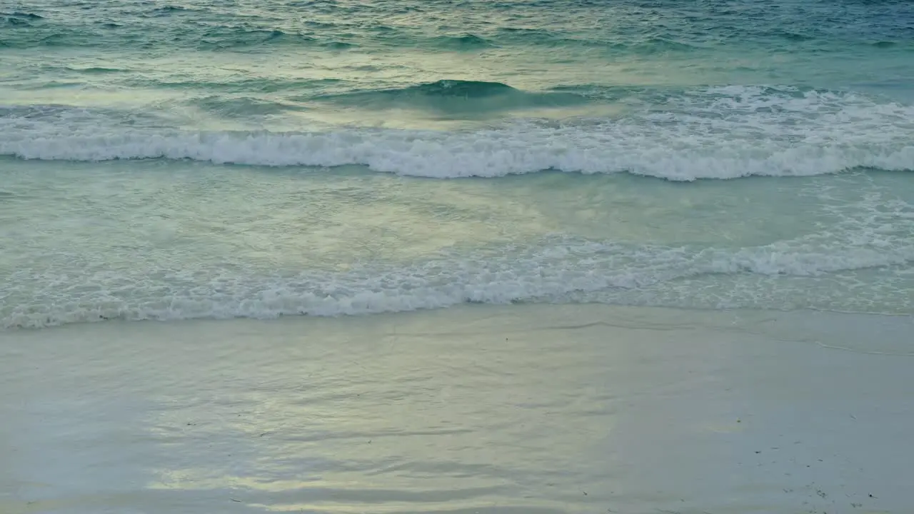 green blue ocean waves coming ashore on a sandy beach