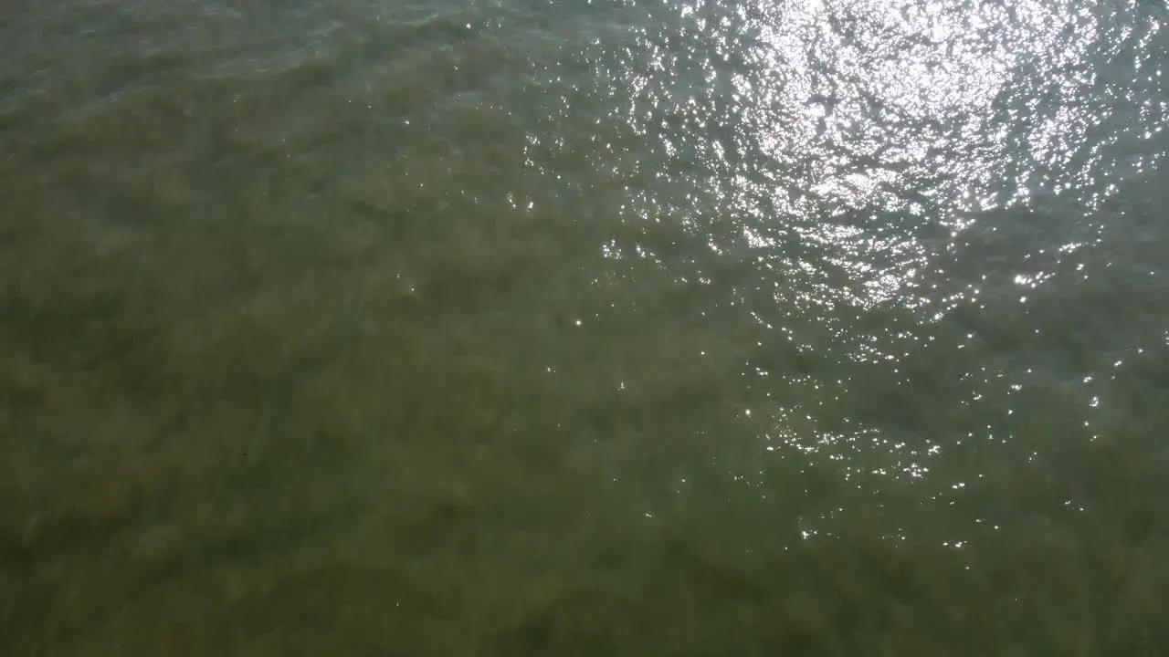 Aerial Over Gentle North Sea Waters With Sun Light Reflected On Surface