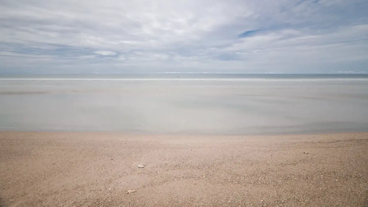 timelapse the beach with white sand and wave from peaceful sea in sunshine daytime