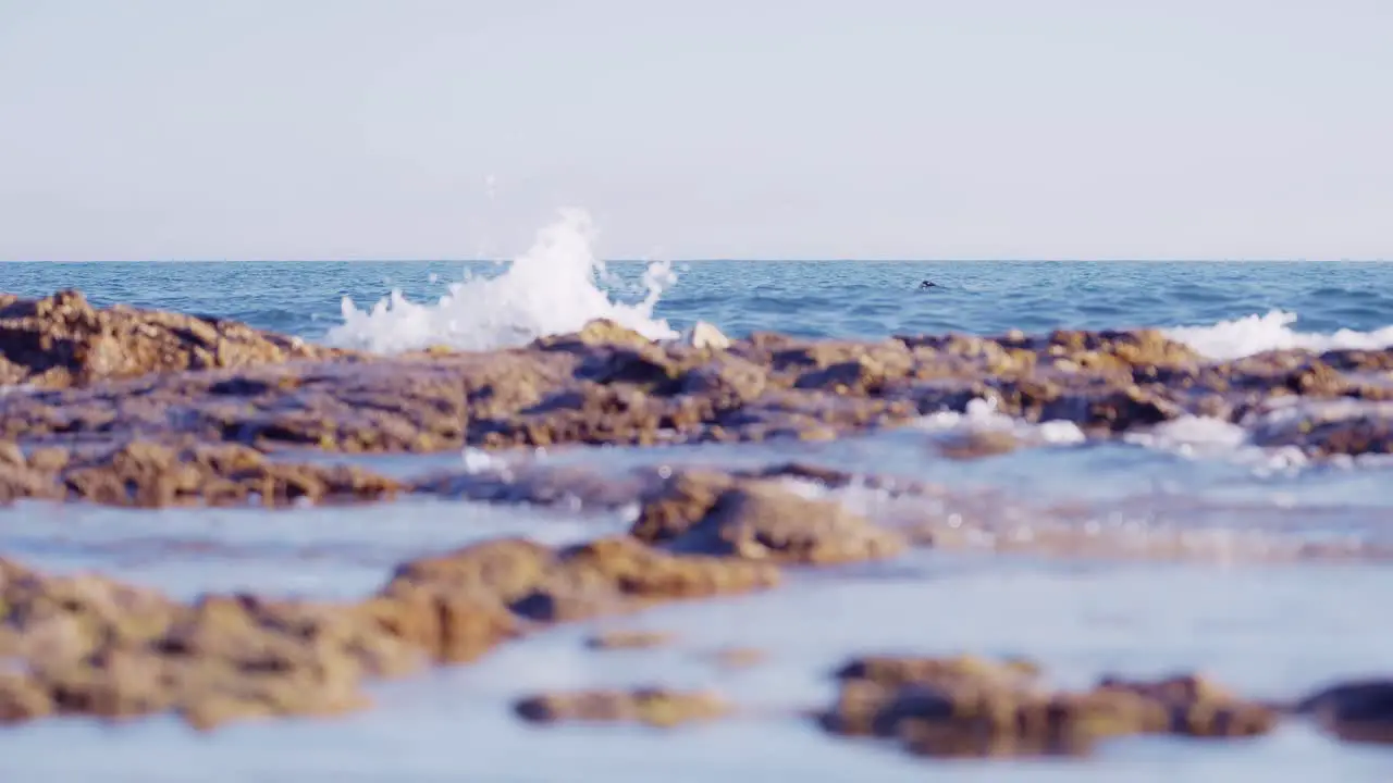 Slow motion coastline with swimmer on the background