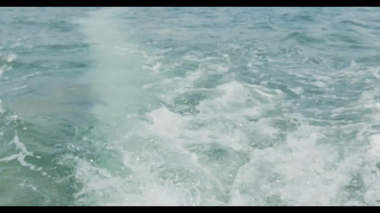 close up shot of the water behind an outboard motor on a boat