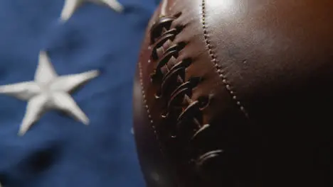 Camera Pushes In For Close Up Studio Shot Of American Football On Stars And Stripes Flag 