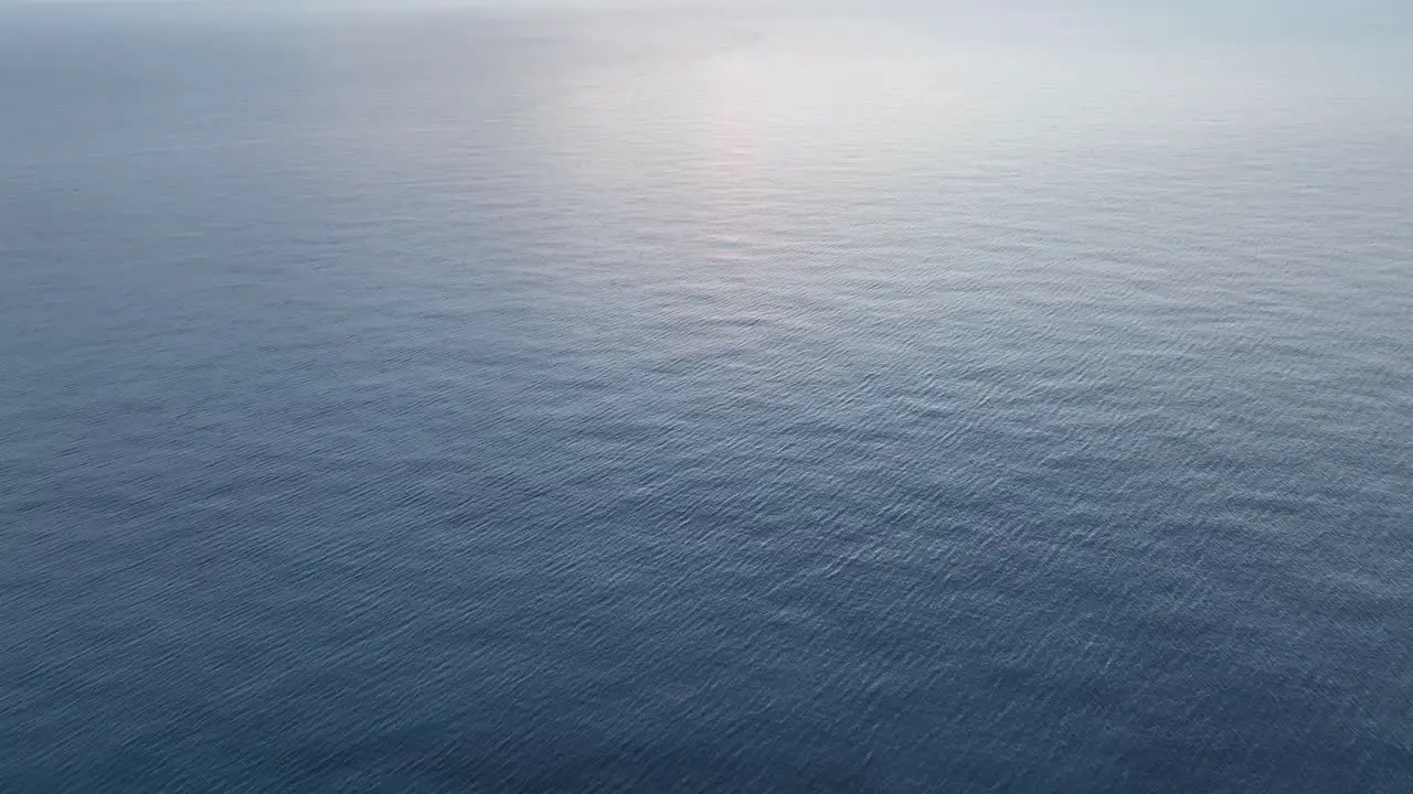 Drone shot panning up to reveal a sunset over the Mediterranean Sea