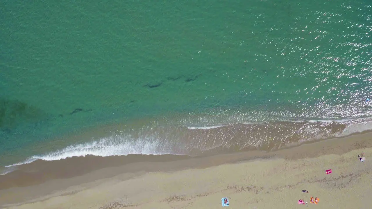 Static aerial shot of the beach shore and the turquoise ocean in Marbella Spain