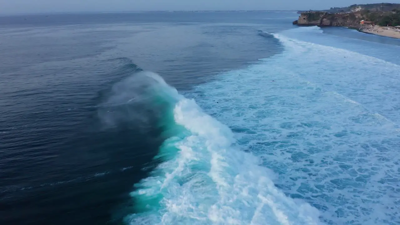 Waves and Surfers on Bali Island South Coast on Indian Ocean Cinematic Twilight Aerial