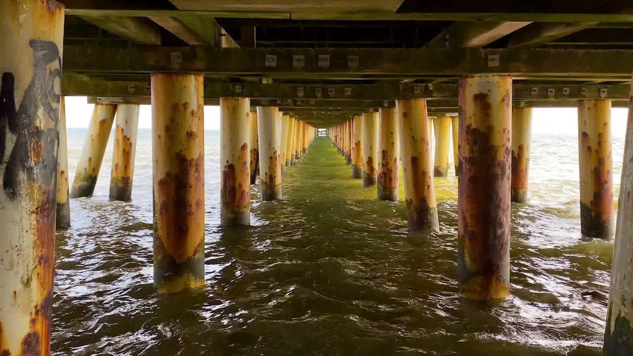 Below pier on shore of Poland with rustic pillars Gdynia Orlowo