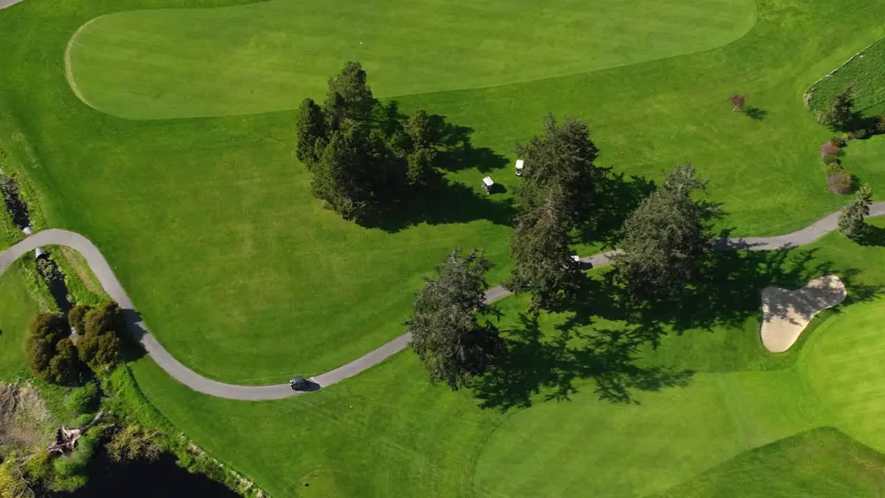 Aerial shot of golf carts meandering through the green searching for their balls